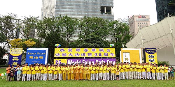 二零一七年五月二日，新加坡法轮功学员在芳邻公园庆祝即将来临的世界法轮大法日。图为学员们集体合影，虔敬合十，恭祝师尊生日快乐。（明慧网）