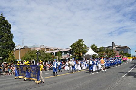 由多个方队组成的法轮大法团体游行队伍出现在街头。 （唐风/大纪元）
