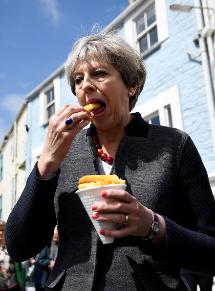 英国媒体劝告政客，最好不要当众吃东西，因为太影响形象了，即使干净整洁的首相也不例外。但是保守党的支持者表示，即使首相把番茄酱蹭到鼻子上，他们还会把票投给她，因为人们不关心她怎么吃薯条，人们只关心她如何应对脱欧的难题。(DYLAN MARTINEZ/AFP/Getty Images)