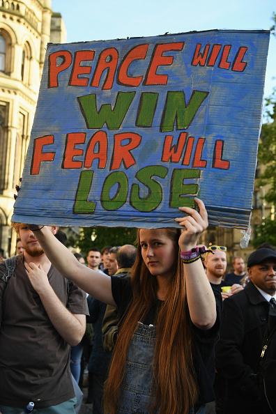 參加燭光守夜的人們舉著「和平終將獲勝，恐懼必將失敗」的標語。(Photo by Jeff J Mitchell/Getty Images)