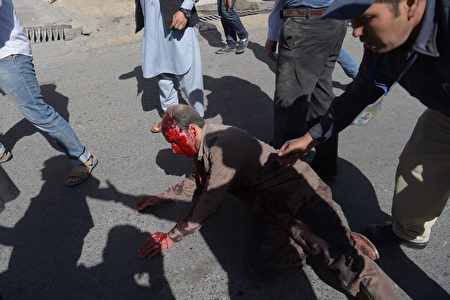 EDITORS NOTE: Graphic content / A wounded Afghan man receives assistance at the site of a car bomb attack in Kabul on May 31, 2017. A massive blast rocked Kabul's diplomatic quarter during the morning rush hour on May 31, the latest attack to hit the Afghan capital. / AFP PHOTO / SHAH MARAI (Photo credit should read SHAH MARAI/AFP/Getty Images)