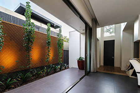 （原本狭窄的外部空间，通过有纹理的金属板、植物及灯光的处理，为室内空间创造了独特的背景。Whyte Gardens提供）