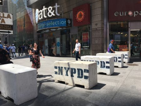 路口处更“夸张”，五个白色的水泥墩子排成一排，上面还印了蓝色的NYPD字样。每个路口大概有二十个这样的墩子，从42街一直铺到48街。