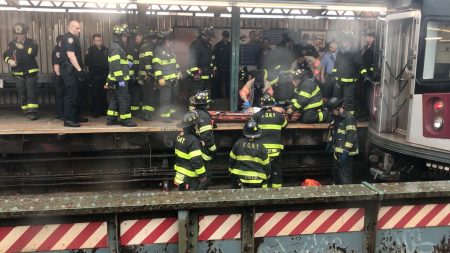 被撞男子被消防员和警察抬上7号线103街-可乐娜广场站月台。