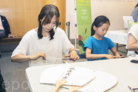韓國端午節體驗傳統文化。5月30日韓國國立民俗博物館舉行端午節體驗傳統文化活動。圖為民眾在做長命縷。（全景林／大紀元）