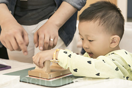 韓國端午節體驗傳統文化。5月30日韓國國立民俗博物館舉行端午節體驗傳統文化活動。圖為孩子們在打印端午符籍。（全景林／大紀元）