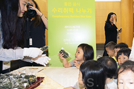 韓國端午節體驗傳統文化。5月30日韓國國立民俗博物館舉行端午節體驗傳統文化活動。圖為分享山牛蒡蒸糕。（全景林／大紀元）