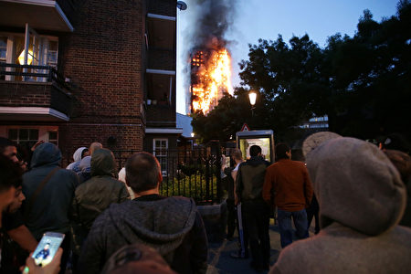 6月14日凌晨，倫敦24層的格倫費爾大廈發生大火，整棟公寓樓完全被大火吞噬。圖為圍觀的當地居民。(DANIEL LEAL-OLIVAS/AFP/Getty Images)