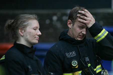 6月14日凌晨，倫敦24層的格倫費爾大廈發生大火，整棟公寓樓完全被大火吞噬。圖為消防員疲於滅火。(DANIEL LEAL-OLIVAS/AFP/Getty Images)