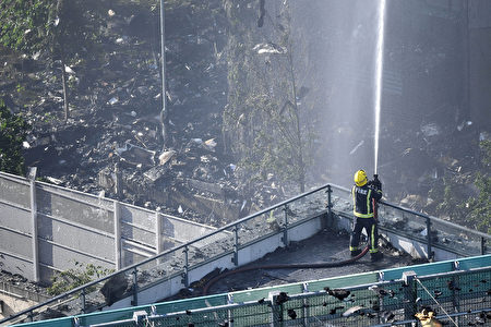 6月14日凌晨，倫敦24層的格倫費爾大廈發生大火，整棟公寓樓完全被大火吞噬。圖為消防員疲於滅火。(Leon Neal/Getty Images)