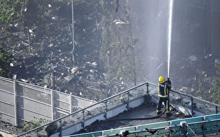 6月14日凌晨，伦敦24层的格伦费尔大厦发生大火，整栋公寓楼完全被大火吞噬。图为消防员疲于灭火。(Leon Neal/Getty Images)