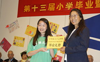 侨立中文学校毕业生代表李奕丹致赠礼物给母校，由校长刘红(右)代表接受。(廖述祥/大纪元)
