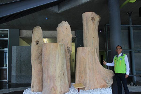三星乡长黄锡镛与三星乡公所新厅舍的桧木装置艺术。（三星乡公所提供）