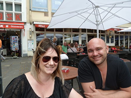 Patrick Fleckenstein（右）和Caroline Frank坐在老市場的咖啡館裡，全程聽了法輪功集會上的發言。（文婧／大紀元）
