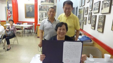 中華公所義工錢英收到石婆婆送來的感謝信，開心與她的先生章德利（左后）與同事。