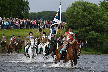 SELKIRK, SCOTLAND - JUNE 16: Standard bearer Kieran Riddell fords the river Ettrick with his attendants as they take part in the town's Common Riding, one of the oldest Borders festivals on June 16, 2017 in Selkirk ,Scotland. The event dating from the Battle of Flodden in 1513, remembers the story of Flodden, when Selkirk sent 80 men into battle with the Scottish King. One man returned, bearing a blood stained English flag. (Photo by Jeff J Mitchell/Getty Images)