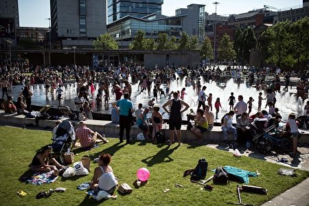 不要以为只有中国人在炎热的天气里会到海边“下饺子”，英国人也一样。近日，英国经历罕见的连续高温天气，不少人都跑到有水的地方去了。就连曼彻斯特的Piccadilly Gardens里面这样的喷泉里，都站满了戏水的大人和小孩。（ OLI SCARFF/AFP/Getty Images)