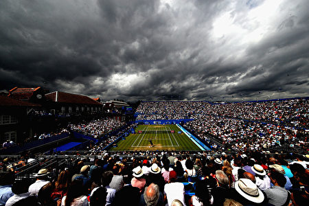 英国的天气阴晴不定，刚才还是晴空万里，转眼就阴云密布。6月24日，人们正在伦敦西部肯辛顿的女王俱乐部观看网球赛，天空突然阴云滚滚。(Julian Finney/Getty Images)