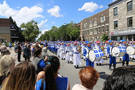来自美国纽约、魁北克蒙特利尔的法轮大法天国乐团以及魁北克当地法轮功学员的功法展示方阵，逾200人的队伍在魁北克游行中蔚为壮观。（易柯 / 大纪元）