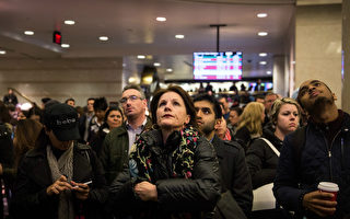 图：乘客于宾州车站大厅等候列车月台资讯。（Andrew Burton／Getty Images）