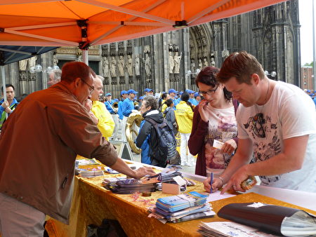 在科隆大教堂前，當場有路人簽名反對中共活摘法輪功學員器官。（曹工 ／大紀元）