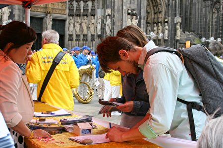 在科隆大教堂前，當場有路人簽名反對中共活摘法輪功學員器官。（曹工 ／大紀元）