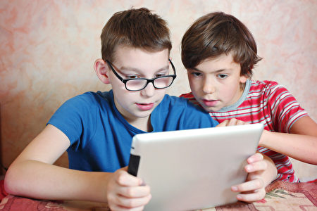 过多使用平板电脑、手机，儿童近视数量大增。（Shutterstock）