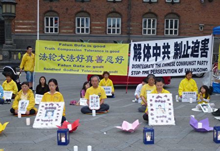 2017年7月20日晚，丹麦法轮功学员在首都市政厅前点燃蜡烛，追悼在中共18年残酷迫害中失去生命的中国法轮功学员。（林达/大纪元）