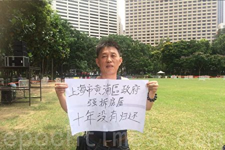 来自上海的李先生来港参加七一游行。他拿着一幅“上海市黄浦区政府 强拆房屋 十年没有归还”标语表达诉求。（梁珍／大纪元）