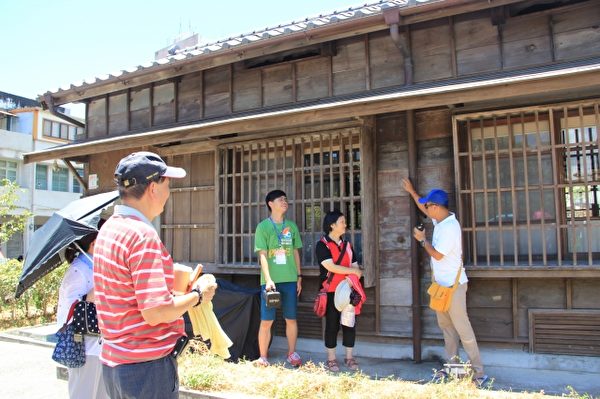 导览人黎万青详细说明木房子的结构与用意。（谢月琴／大纪元）