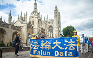 由法轮大法学员组成的游行队伍穿行于剑桥大学著名景点，不少游人驻足观看。（Laphare/大纪元）