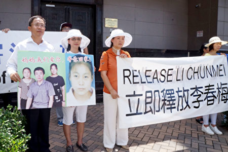 与李春梅一家相识十多年的刘晓斌夫妇手举好友一家照片，要求中共立即释放李春梅。（易永琦／大纪元）