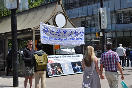 圖說：溫哥華藝術館前法輪功學員真相點，溫哥華人震驚於中共活摘器官的真相，紛紛簽名要求制止中共活摘。（唐風/大紀元）