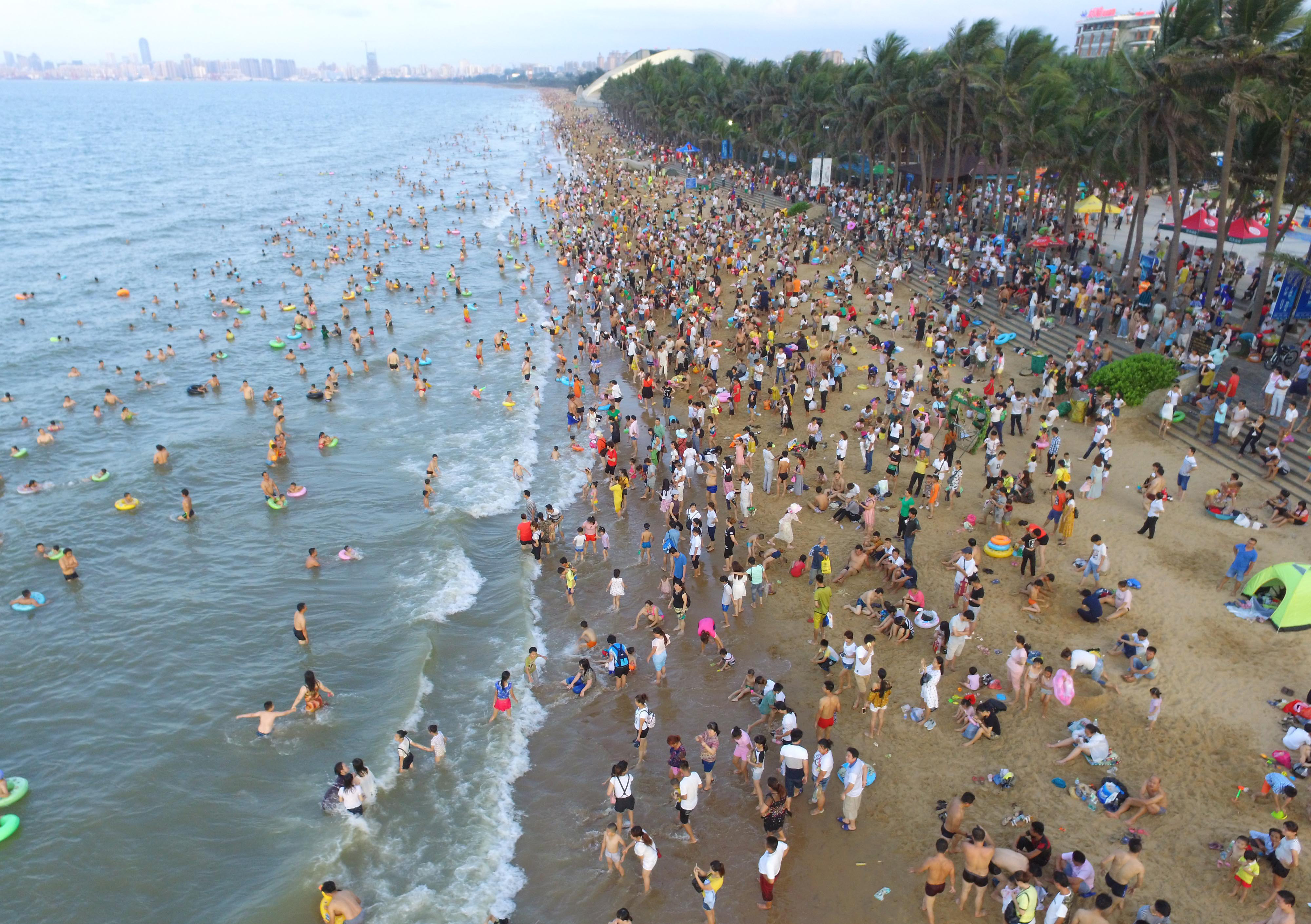 今年夏季大陆酷热,很多人早早的就去海边。图为5月30日的海口海滩。 (Photo credit should read STR/AFP/Getty Images)