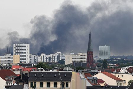 Dark smoke hangs over the Schanzenviertel district on July 7, 2017 in Hamburg, northern Germany, where leaders of the world's top economies gather for a G20 summit. Protesters clashed with police and torched patrol cars in fresh violence ahead of the G20 summit, police said. German police and protestors had clashed already on Thursday (July 6, 2017) at an anti-G20 march, with police using water cannon and tear gas to clear a hardcore of masked anti-capitalist demonstrators, AFP reporters said. / AFP PHOTO / DPA / Boris Roessler / Germany OUT (Photo credit should read BORIS ROESSLER/AFP/Getty Images)