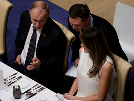 周五（7月7日）的G20晚宴上，梅拉尼娅跟普京交谈愉快。(KAY NIETFELD/AFP/Getty Images)