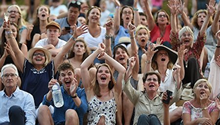 赢了！温布尔登网球赛上，卫冕冠军英国的穆雷带伤上阵，经过两个小时39分的鏖战，终于通过了进入前16名的比赛，观众们欢庆胜利。在这之后，穆雷还成功进入四分之一决赛。(OLI SCARFF/AFP/Getty Images)