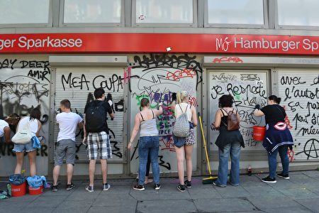 7月9日（周日），在汉堡G20峰会过后，善泽区街头出现了许多志愿者，收拾当地被极端暴力份子打砸抢后留下的残局，其中不少是年轻人。（CHRISTOF STACHE/AFP/Getty Images）