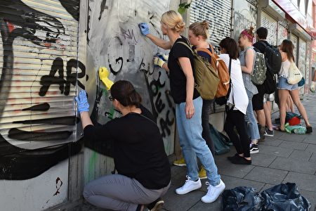 7月9日（周日），在汉堡G20峰会过后，善泽区街头出现了许多志愿者，收拾当地被极端暴力份子打砸抢后留下的残局，其中不少是年轻人。（CHRISTOF STACHE/AFP/Getty Images）