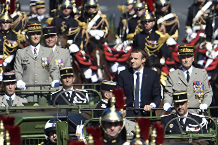 法国总统马克龙在法军总司令的陪同下乘车开导，穿越香榭丽舍大道，后面紧跟着的是骑兵仪仗队。（ALAIN JOCARD/AFP/Getty Images）