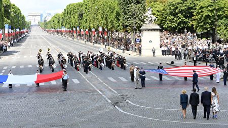 阅兵式结束时，法国和美国总统夫妇走向两国的国旗，在国旗前紧紧握手，象征两国的团结和友谊。（ALAIN JOCARD/AFP/Getty Images）
