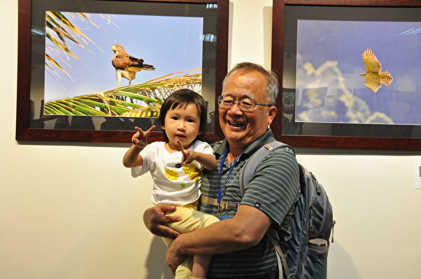祖孙情，参展的摄影家纪木森带着孙女和家人一起看展览，分享美好的经验。（赖月贵／大纪元）