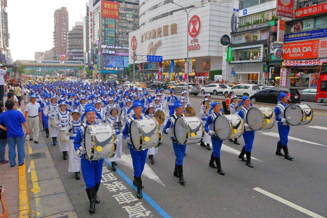 由法轮功学员组成的天国乐团参加台北世大运的嘉年华踩街游行,精神抖擞地行经在台北市热闹的街头。(明慧网)