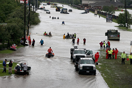 HOUSTON, TX - AUGUST 29: People make their way out of a flooded neighborhood after it was inundated with rain water following Hurricane Harvey on August 29, 2017 in Houston, Texas. Harvey, which made landfall north of Corpus Christi August 25, has dumped nearly 50 inches of rain in and around Houston. (Photo by Scott Olson/Getty Images)