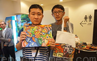 自闭症画家高进宇(左)将自己的美丽画作，转制成商品提袋。（李怡欣／大纪元）