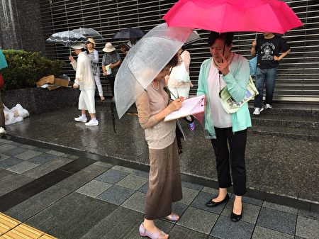 日本法輪功學員8月15日，在東京九段下車站擺真相看板，向人民講真相，並徵集聯署舉報江澤民的簽名，儘管當天遇到大雨，依然有上千名的日本民眾和外國遊客在聯署舉報書上簽了名。（英傑／大紀元）