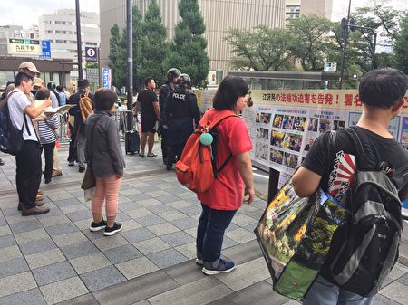 日本部分法輪功學員8月15日，在東京九段下車站擺真相看板，向人民講真相，並徵集聯署舉報江澤民的簽名。（英傑／大紀元）