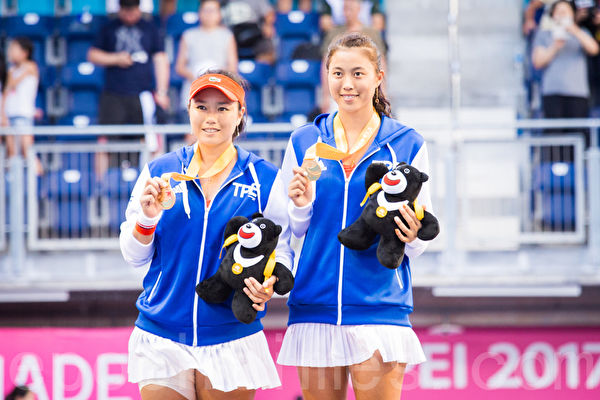 中華隊網球女將詹詠然（左）、詹皓晴（右）姊妹28日在世大運網球女雙決賽，以直落二擊敗對手，拿下台灣在世大運網球賽事首金。（陳柏州／大紀元）