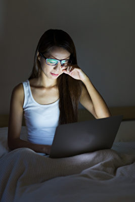 現在青年人習慣睡前刷手機，在黑夜中手機屏幕散射的藍光傷害尤其大。（Shutterstock）