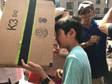 10岁华裔男孩谢山看News杂志学会了用纸箱自制工具观看日全蚀，效果与眼镜看一样。图为他在用纸箱看日全蚀的倒影。